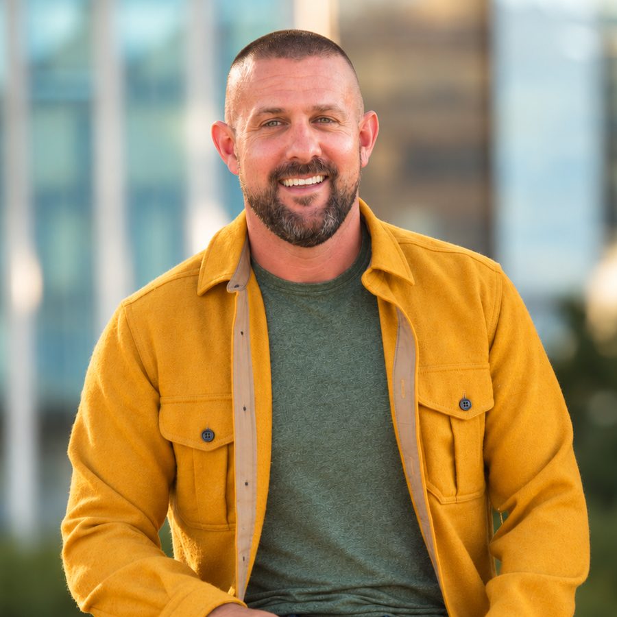 Casey Miller, smiling, seated outdoors