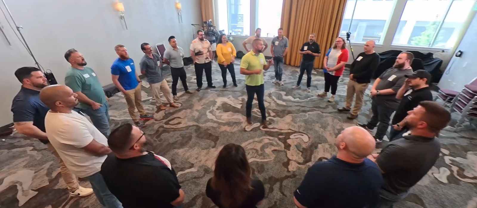Casey Miller facilitating a leadership session with a group standing in a circle